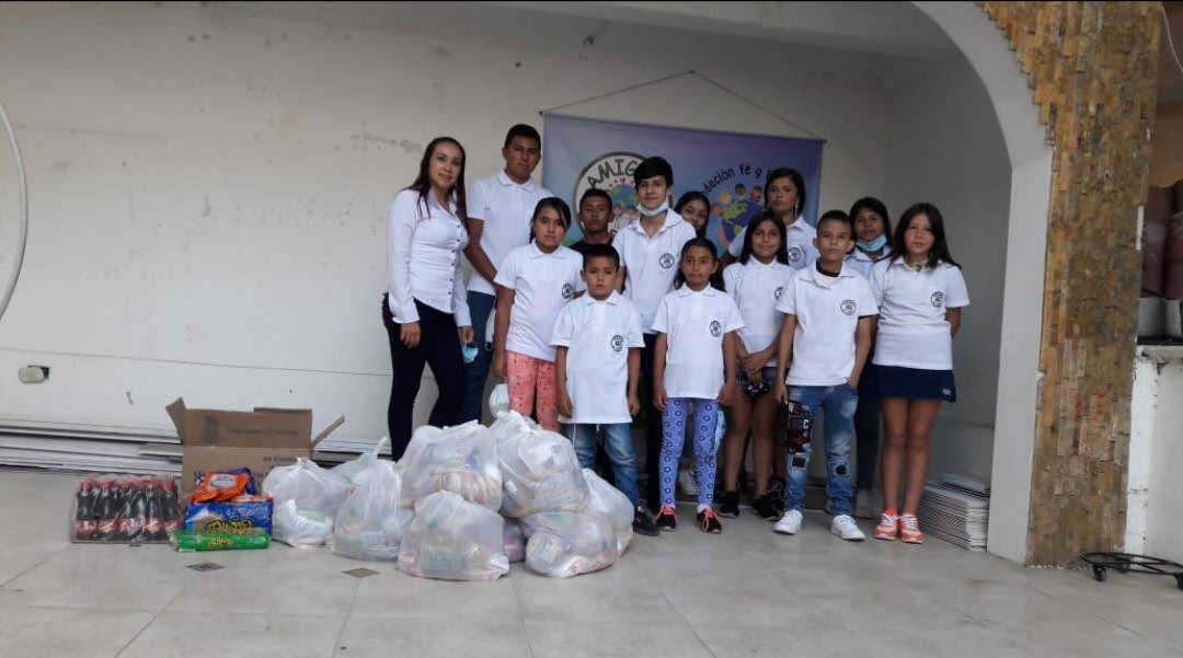 children posing together with bags of food
