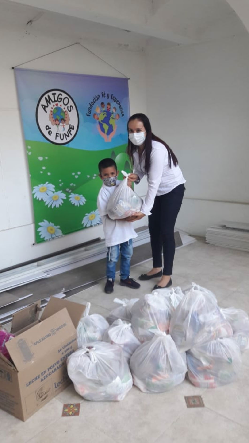 a teacher giving a bag of food to a young boy