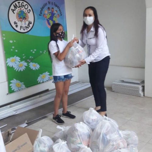 thumbnail of a teacher giving a bag of food to a young girl