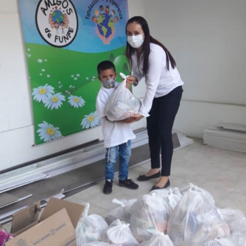 thumbnail of a teacher giving a bag of food to a young boy