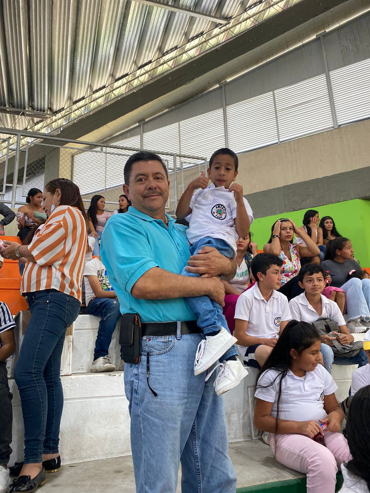 a man holding a child while the child gives a thumbs up