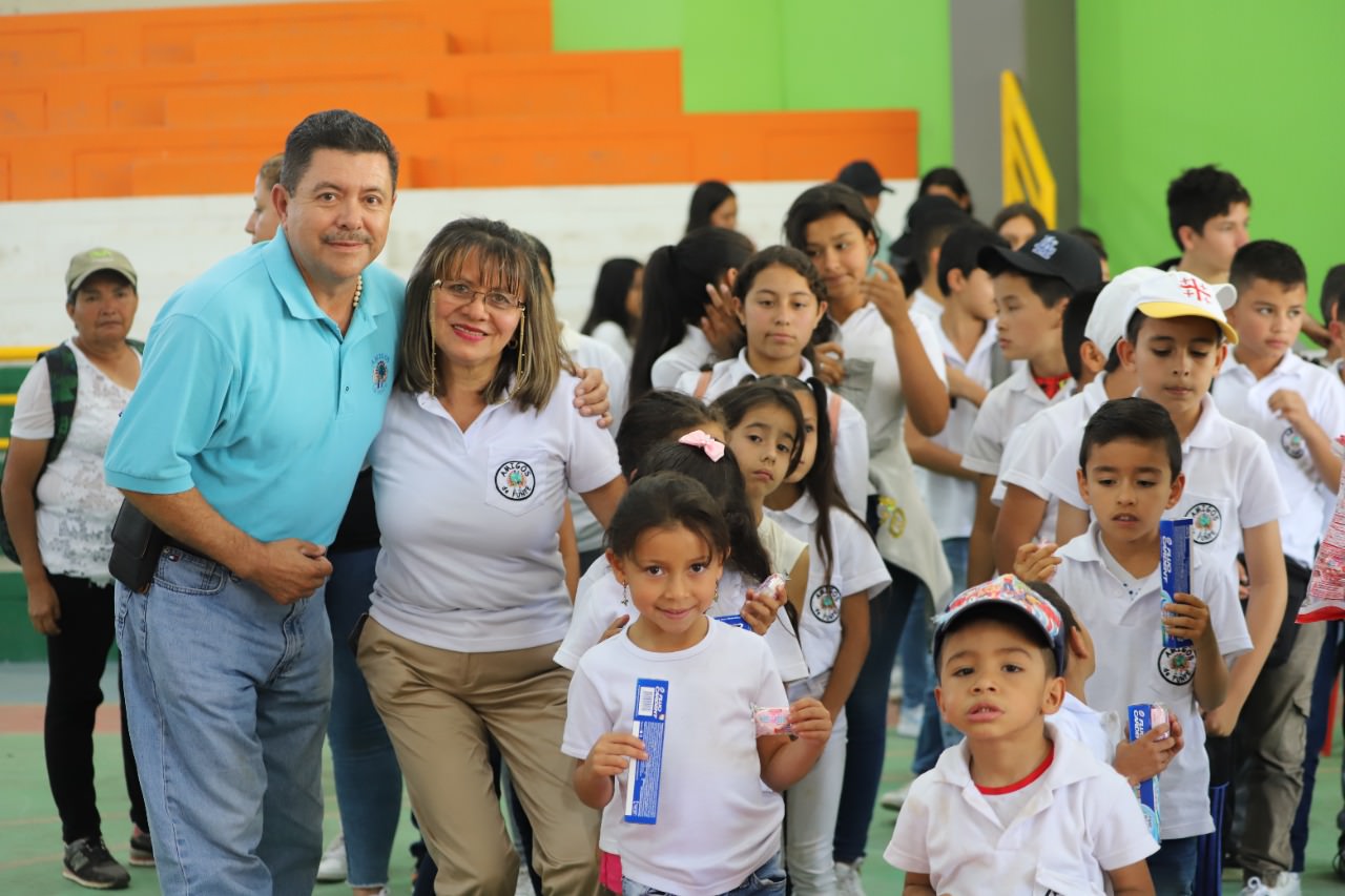 a man and woman pose with children holding snacks