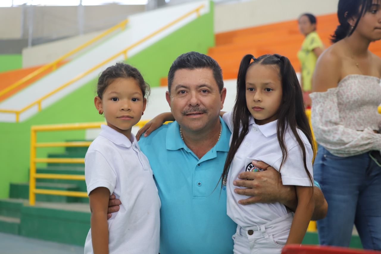 a man poses with 2 children