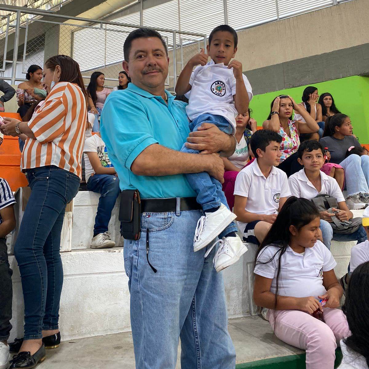 thumbnail of a man holding a child while the child gives a thumbs up