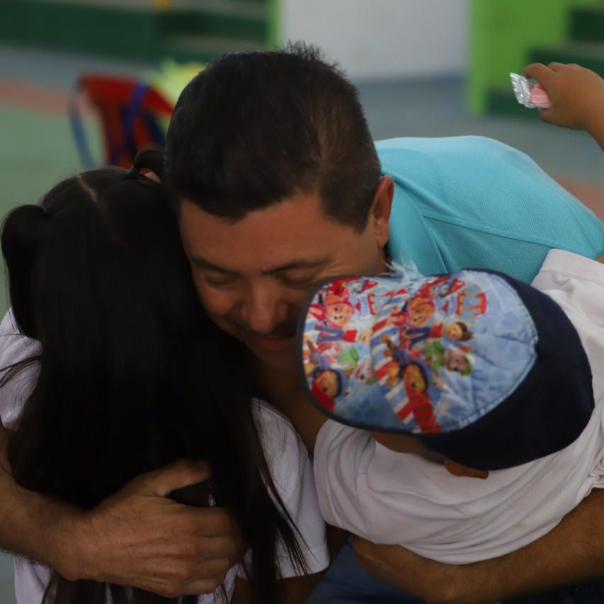 thumbnail of a man hugs and plays with two children
