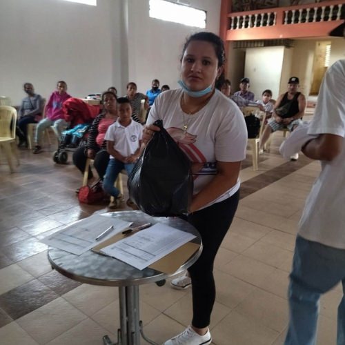 thumbnail of a woman receives a bag of food